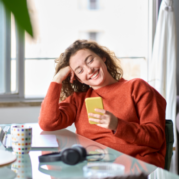 Lady smiling at phone flipped v2 2226115245