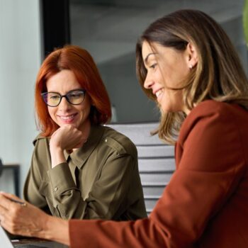 Two women looking at laptop 2429463807