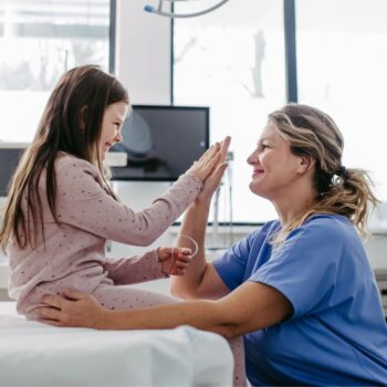 Nurse giving child patient high five 2421530977