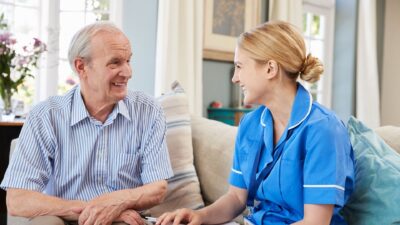 Nurse with male patient at home 774642154