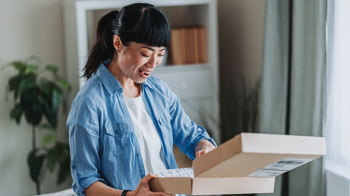 Lady opening parcel smiling 2663284587